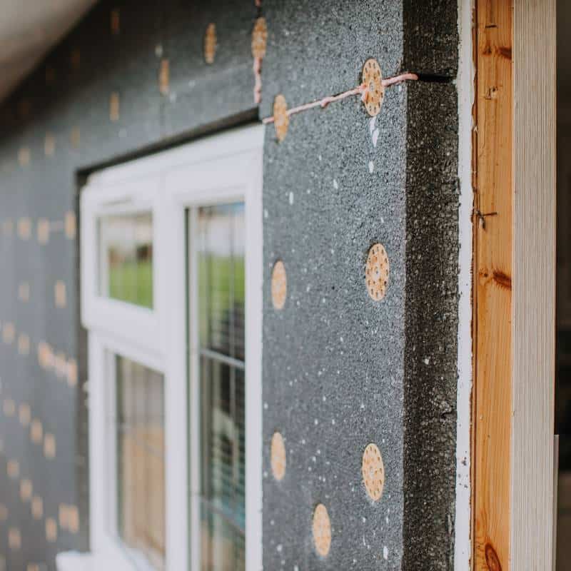 Exterior wall insulation installation process near window.