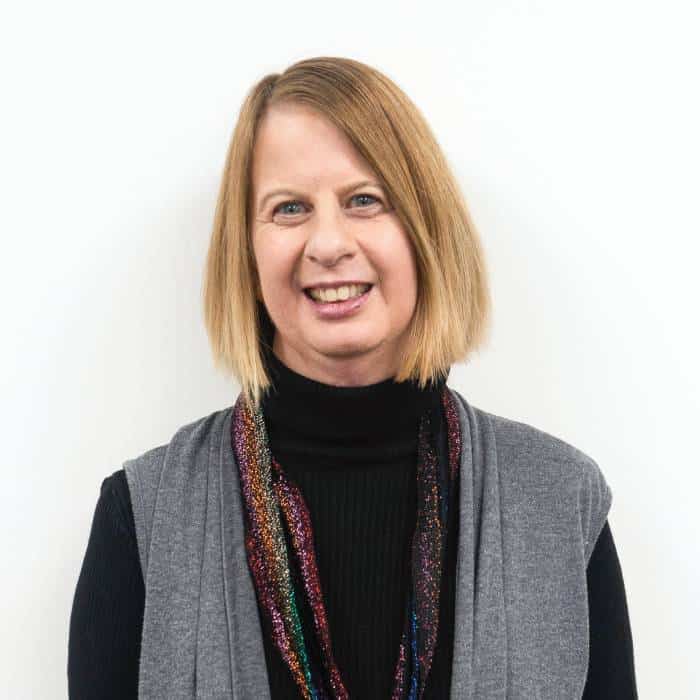 Woman in turtleneck smiling against white background.