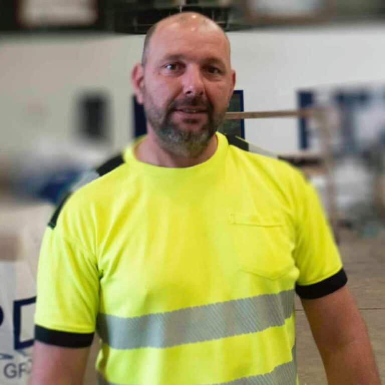 Man in high-visibility safety shirt indoors.