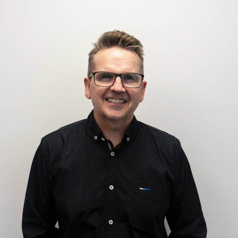 Smiling man in black shirt against white background