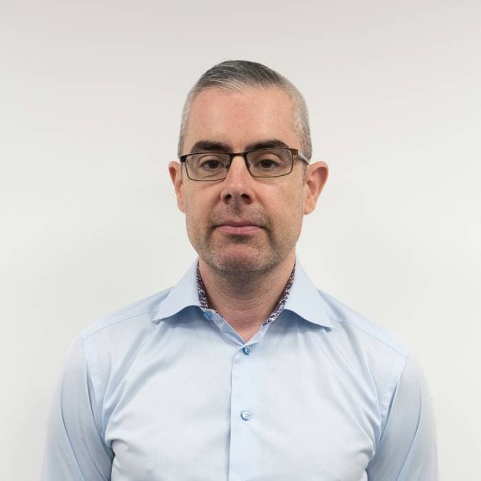 Middle-aged man in blue shirt, professional headshot.