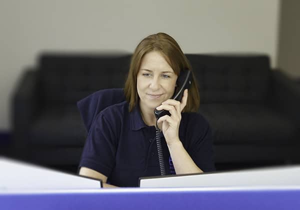 Woman in office speaking on telephone, smiling