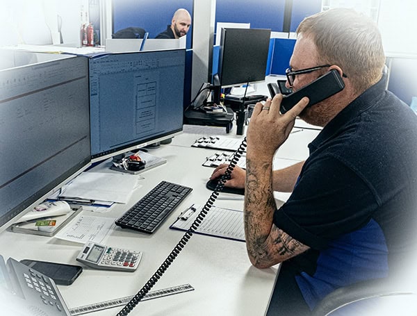 Man on phone in busy office environment